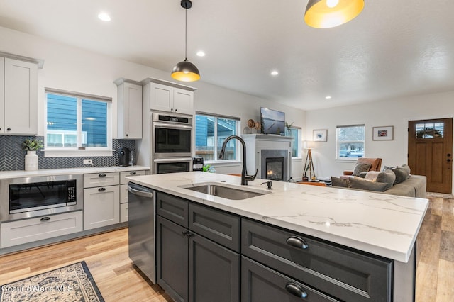 2119 E Lakeside Ave, Coeur Dalene, ID 83814 - kitchen featuring open floor plan, stainless steel appliances, a kitchen island with sink, decorative backsplash, and recessed lighting