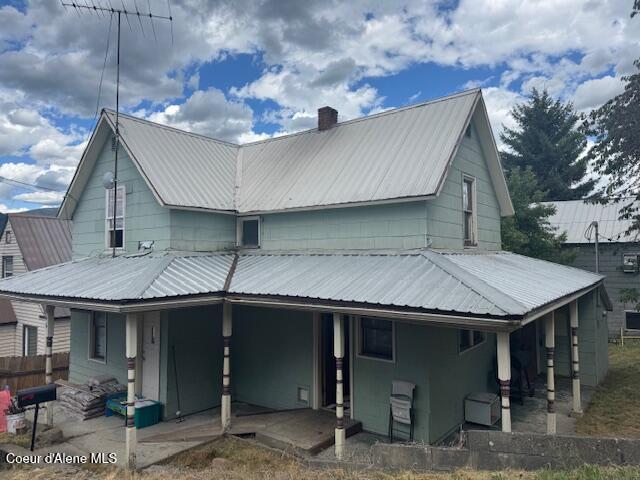 346S S 4th St, Saint Maries, ID 83861 - rear view of house featuring a metal roof, a chimney, and a patio area