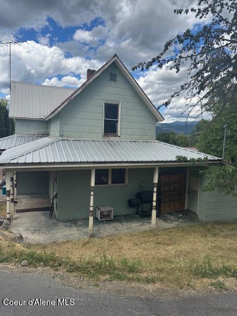 346S S 4th St, Saint Maries, ID 83861 - view of side of property featuring a chimney, a metal roof, and a patio area