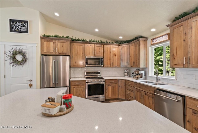 12671 E Trout Pond Rd, Athol, ID 83801 - kitchen with stainless steel appliances, lofted ceiling, light countertops, decorative backsplash, and brown cabinets