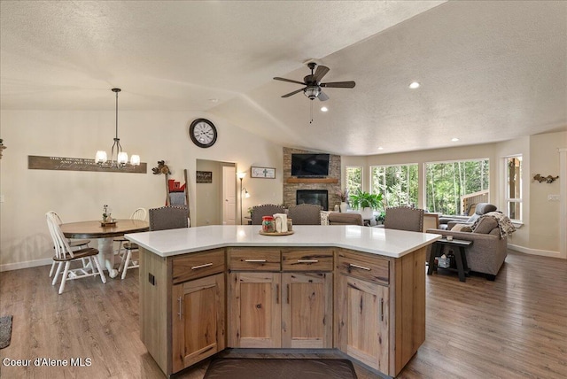 12671 E Trout Pond Rd, Athol, ID 83801 - kitchen with a stone fireplace, dark wood-type flooring, a textured ceiling, ceiling fan, and open floor plan