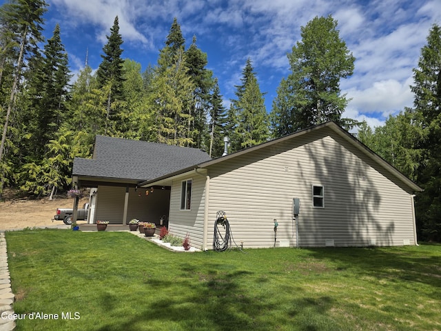 12671 E Trout Pond Rd, Athol, ID 83801 - view of side of home with a lawn, a patio, roof with shingles, and an outdoor hangout area