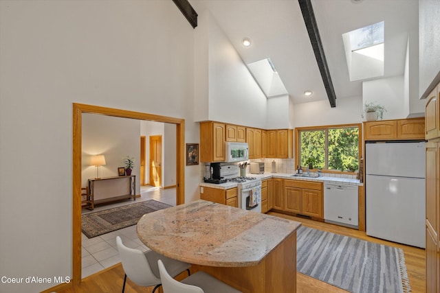 23388 N Teddy Loop, Rathdrum, ID 83858 - kitchen featuring white appliances, a skylight, beam ceiling, high vaulted ceiling, and backsplash