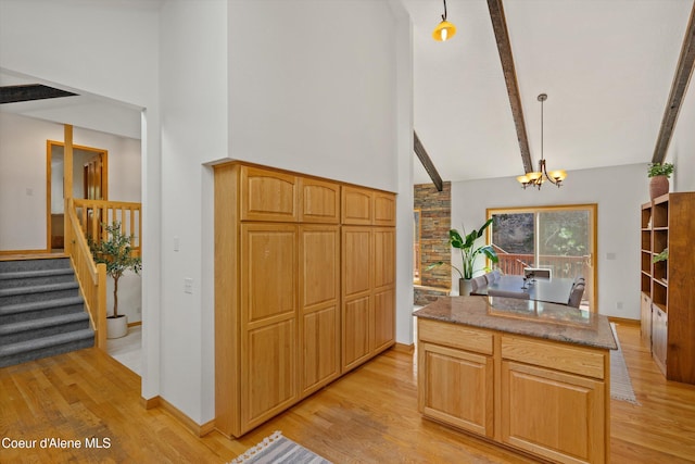 23388 N Teddy Loop, Rathdrum, ID 83858 - kitchen with high vaulted ceiling, light wood finished floors, a chandelier, beamed ceiling, and dark stone countertops