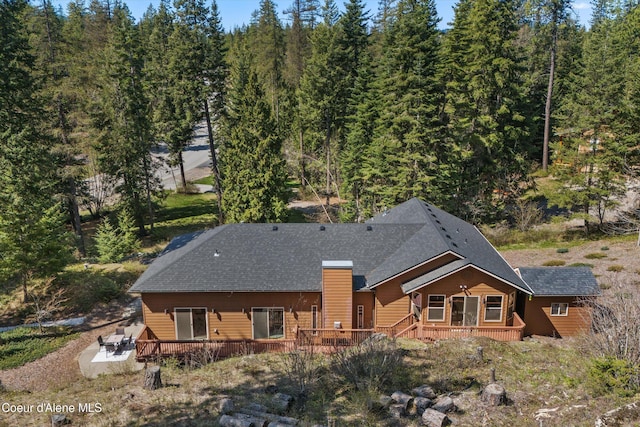 23388 N Teddy Loop, Rathdrum, ID 83858 - rear view of property with a deck, a patio, and a wooded view