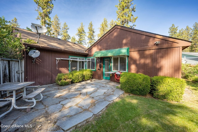628 E Timber Ln, Coeur Dalene, ID 83815 - rear view of house featuring a patio area, a lawn, and a shingled roof