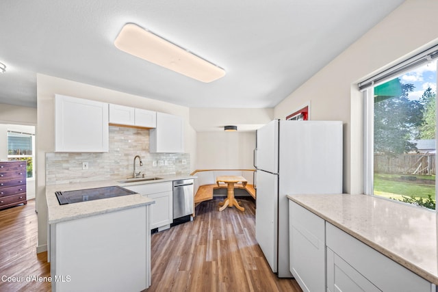 628 E Timber Ln, Coeur Dalene, ID 83815 - kitchen featuring black electric stovetop, dishwasher, freestanding refrigerator, white cabinets, and decorative backsplash