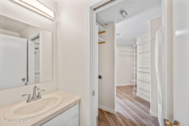 628 E Timber Ln, Coeur Dalene, ID 83815 - bathroom featuring vanity, wood finished floors, and a walk in closet