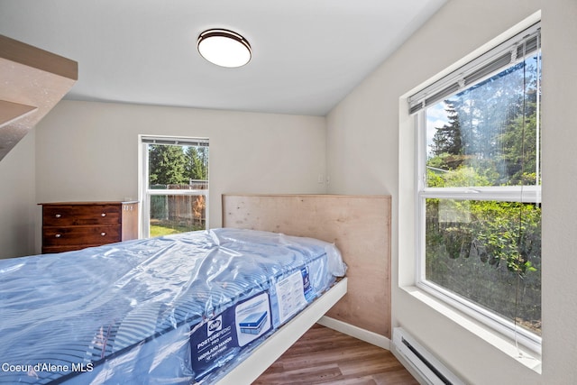 628 E Timber Ln, Coeur Dalene, ID 83815 - bedroom featuring wood finished floors and a baseboard heating unit