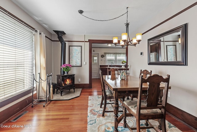 105 E Miller Ave, Coeur Dalene, ID 83814 - dining area with a wood stove, a chandelier, and light wood-style flooring