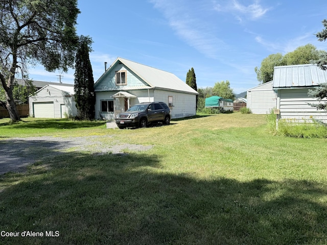407 Hope St, Kootenai, ID 83840 - view of side of home featuring a metal roof, a lawn, a garage, and an outdoor structure