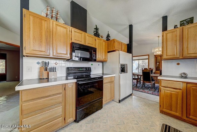 9218 W Rockford Bay Rd, Coeur Dalene, ID 83814 - kitchen with black appliances, lofted ceiling, a chandelier, decorative backsplash, and light tile patterned floors