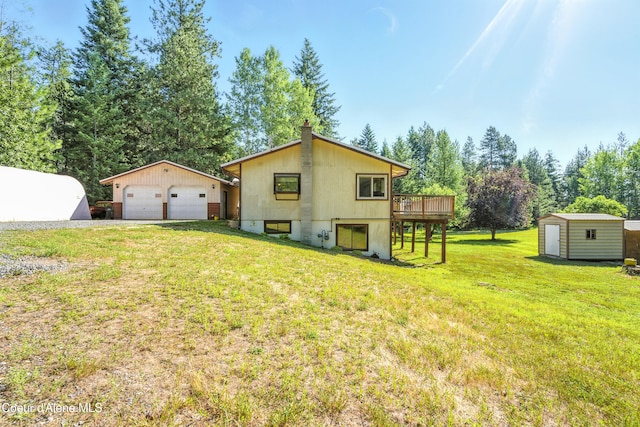 1655 Gun Club Rd, Sagle, ID 83860 - rear view of house with a garage, a deck, a storage shed, a yard, and a chimney
