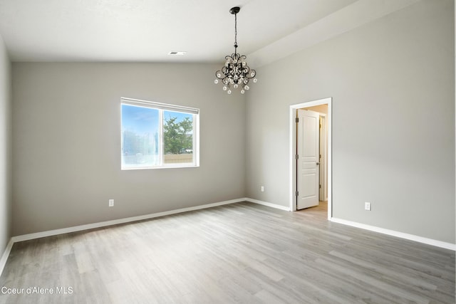 1254 E Bogie Dr, Post Falls, ID 83854 - empty room featuring wood finished floors, a chandelier, and vaulted ceiling