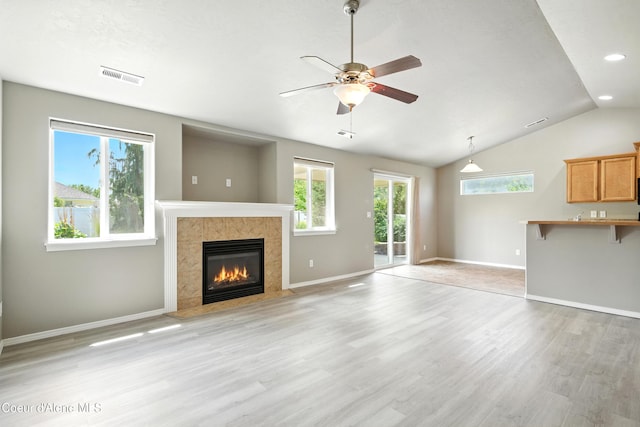 1254 E Bogie Dr, Post Falls, ID 83854 - unfurnished living room featuring a tiled fireplace, light wood-style floors, ceiling fan, vaulted ceiling, and recessed lighting