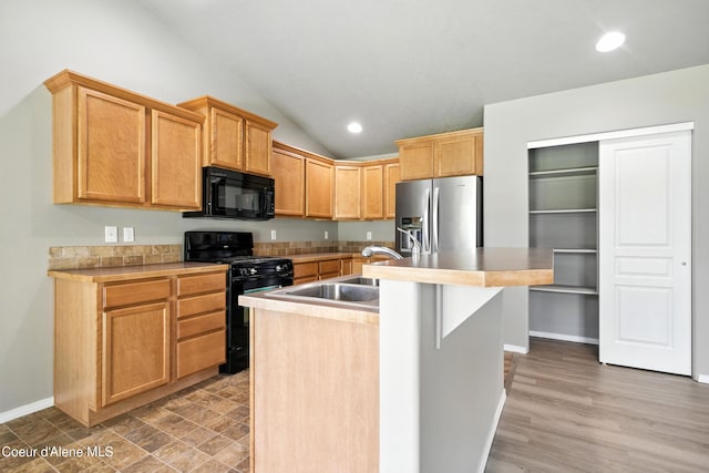 1254 E Bogie Dr, Post Falls, ID 83854 - kitchen with black appliances, lofted ceiling, a center island with sink, light countertops, and recessed lighting