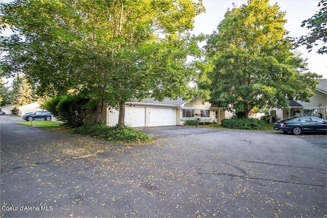 4922 W Village Blvd # 5, Rathdrum, ID 83858 - view of property hidden behind natural elements with driveway and a garage