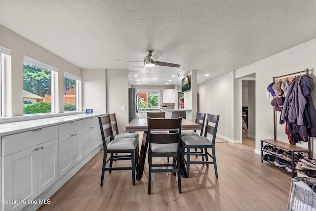 5299 W Green Ct # 23, Rathdrum, ID 83858 - dining area with light wood-style floors, a textured ceiling, and a ceiling fan