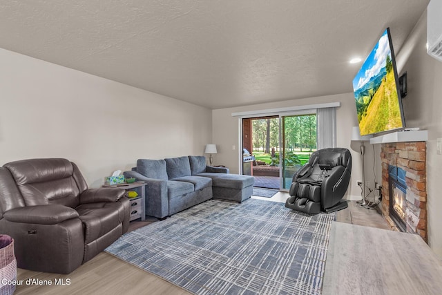 5299 W Green Ct # 23, Rathdrum, ID 83858 - living room with wood finished floors, a stone fireplace, and a textured ceiling