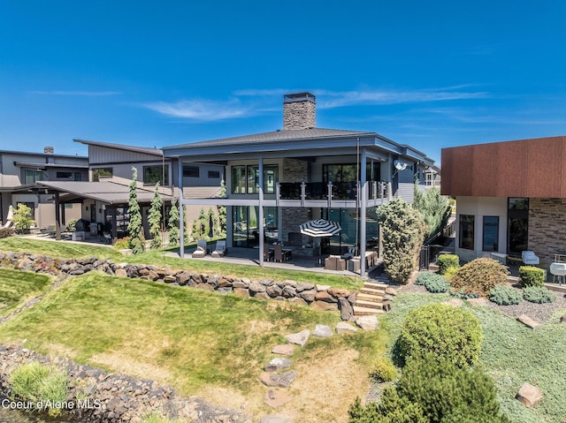 1758 W Bellerive Ln, Coeur Dalene, ID 83814 - rear view of property with a patio area, a chimney, and a yard