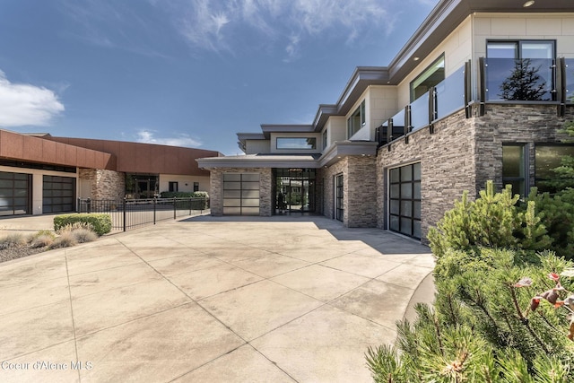 1758 W Bellerive Ln, Coeur Dalene, ID 83814 - view of front of home with stone siding, driveway, and a patio