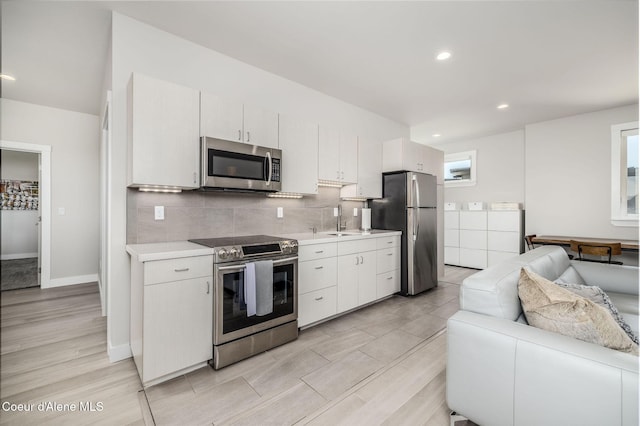 1758 W Bellerive Ln, Coeur Dalene, ID 83814 - kitchen with appliances with stainless steel finishes, open floor plan, light countertops, tasteful backsplash, and light wood-type flooring