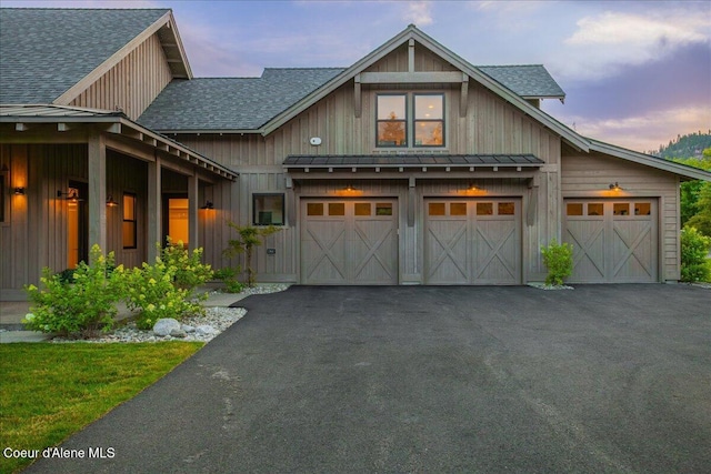 428 W Beach Ct, Dover, ID 83825 - view of front of property featuring a standing seam roof, asphalt driveway, board and batten siding, a shingled roof, and a metal roof