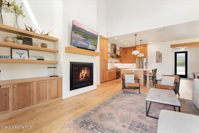 428 W Beach Ct, Dover, ID 83825 - living room with light wood finished floors, a glass covered fireplace, and a high ceiling