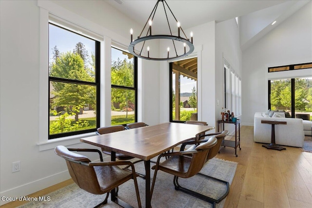428 W Beach Ct, Dover, ID 83825 - dining space featuring light wood-type flooring, plenty of natural light, a chandelier, and high vaulted ceiling