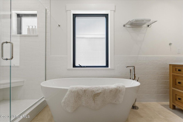 428 W Beach Ct, Dover, ID 83825 - full bathroom with tile walls, a stall shower, wainscoting, a soaking tub, and vanity