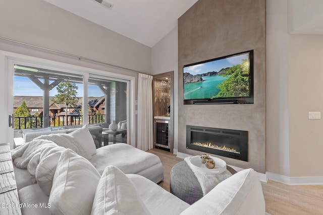 4732 S Arrow Point Dr # 304, Harrison, ID 83833 - living room featuring beverage cooler, a large fireplace, light wood-type flooring, and high vaulted ceiling