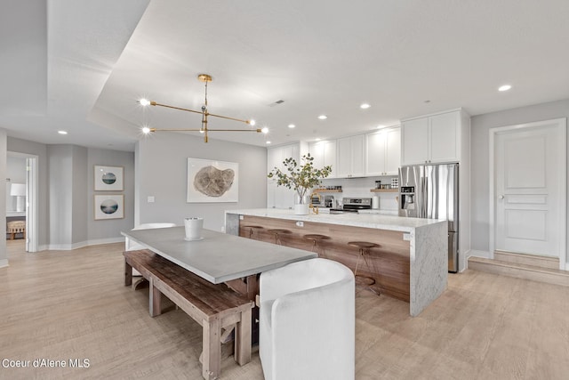 4732 S Arrow Point Dr # 304, Harrison, ID 83833 - dining space featuring stacked washing machine and dryer, light wood-style floors, recessed lighting, and a chandelier