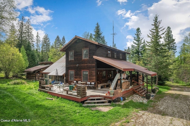 854 Two Tail Rd, Bonners Ferry, ID 83805 - rear view of property featuring a wooden deck, a lawn, and a metal roof