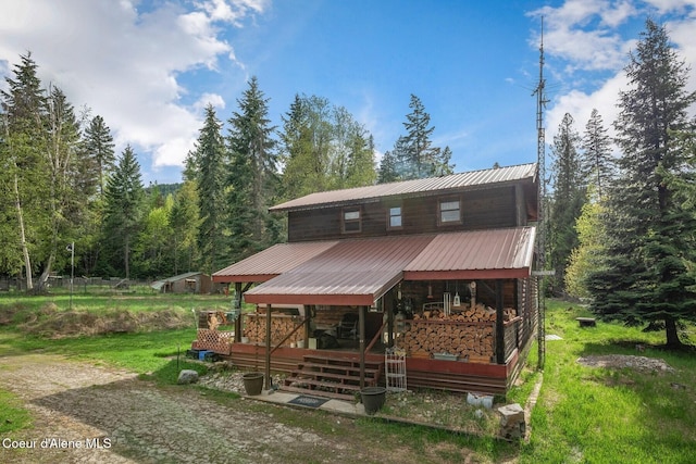854 Two Tail Rd, Bonners Ferry, ID 83805 - view of front of home with a metal roof, a forest view, and a porch