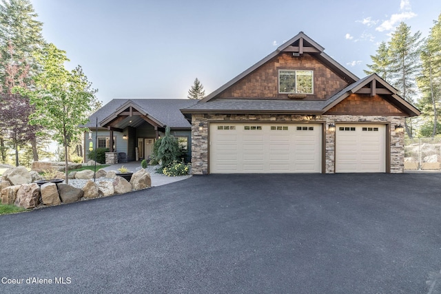 16749 W Cade Rd, Hauser, ID 83854 - craftsman-style house with stone siding, a garage, driveway, and a shingled roof