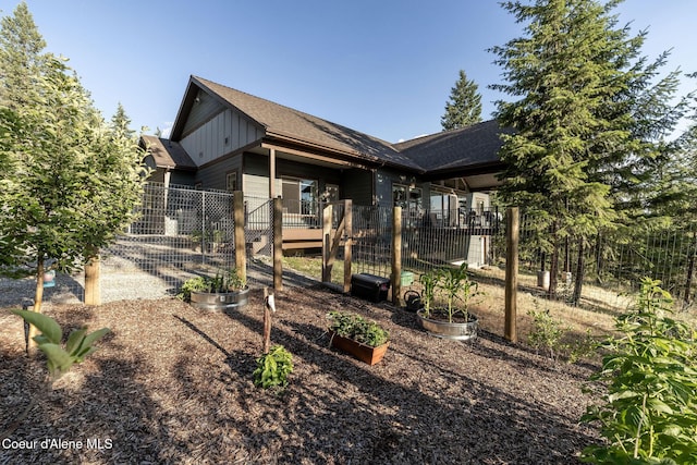 16749 W Cade Rd, Hauser, ID 83854 - view of front of home with board and batten siding, a garden, and roof with shingles