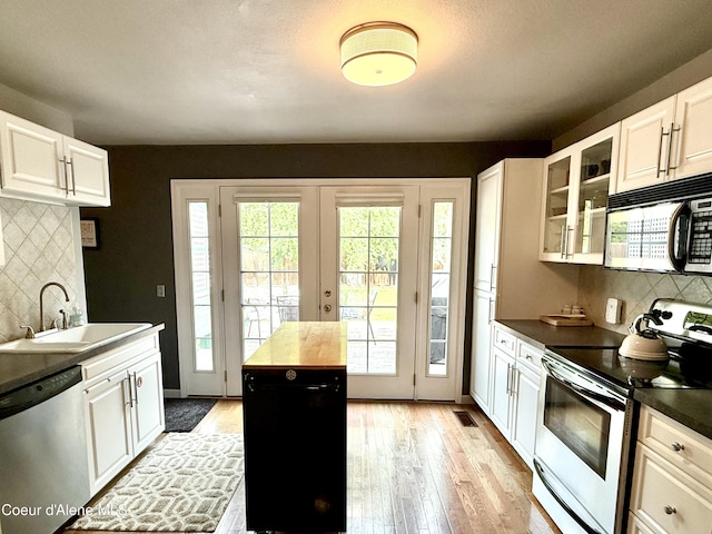 912 N 5th St, Coeur Dalene, ID 83814 - kitchen with appliances with stainless steel finishes, light wood-type flooring, and tasteful backsplash