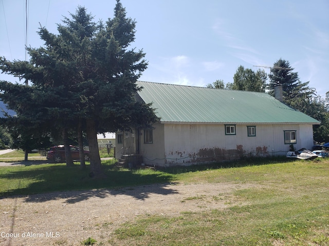 701 N Pine St, Clark Fork, ID 83811 - view of side of property with a metal roof, a yard, a chimney, and entry steps