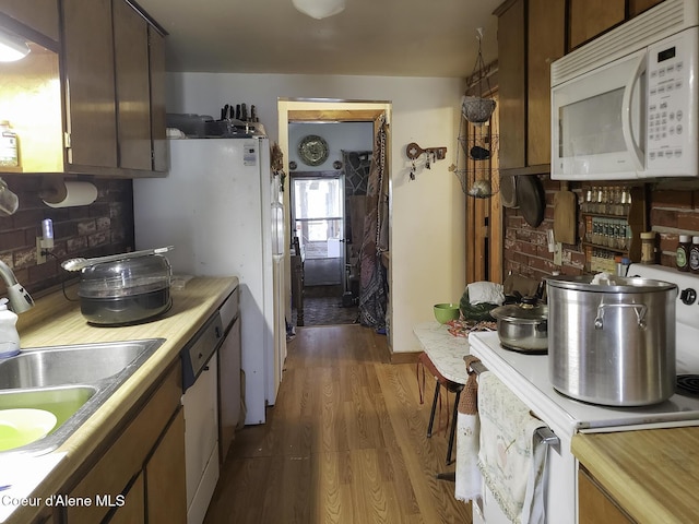 701 N Pine St, Clark Fork, ID 83811 - kitchen featuring white appliances, wood finished floors, light countertops, and backsplash