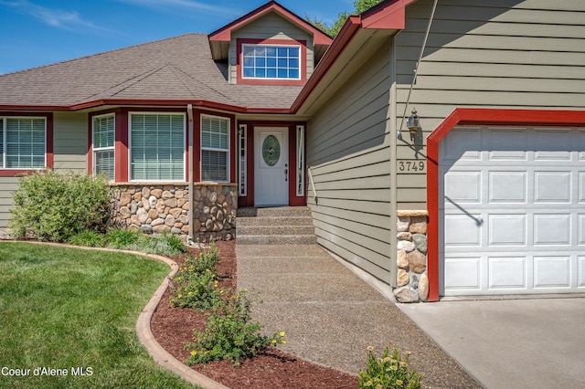 3749 N Miners Loop, Coeur Dalene, ID 83815 - entrance to property with stone siding, roof with shingles, driveway, and a garage