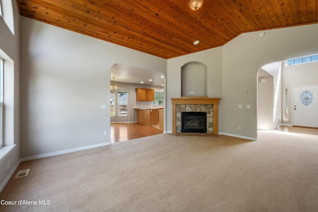 3749 N Miners Loop, Coeur Dalene, ID 83815 - unfurnished living room with wooden ceiling, high vaulted ceiling, light colored carpet, arched walkways, and a fireplace