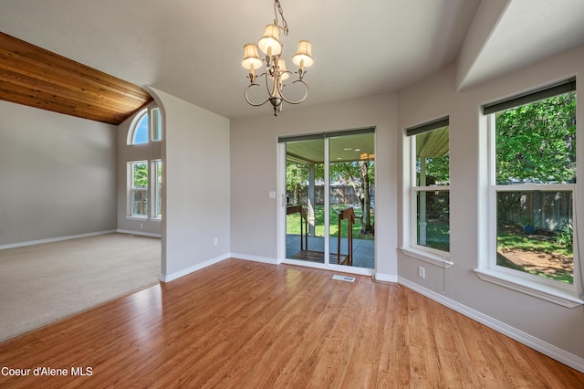 3749 N Miners Loop, Coeur Dalene, ID 83815 - empty room featuring a chandelier, wood finished floors, and vaulted ceiling