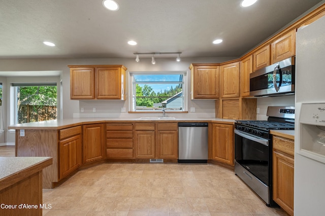 3749 N Miners Loop, Coeur Dalene, ID 83815 - kitchen with stainless steel appliances, light countertops, a peninsula, recessed lighting, and brown cabinets