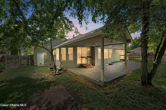 3749 N Miners Loop, Coeur Dalene, ID 83815 - back of property at dusk featuring a patio and a fenced backyard