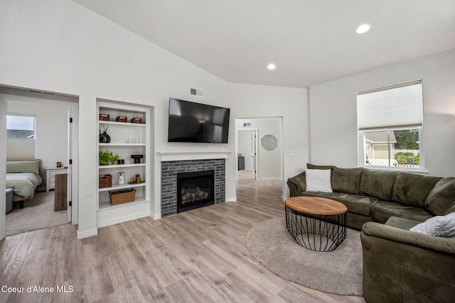 7991 N Girard Cir, Coeur Dalene, ID 83815 - living area with light wood-type flooring, a tiled fireplace, built in shelves, and recessed lighting