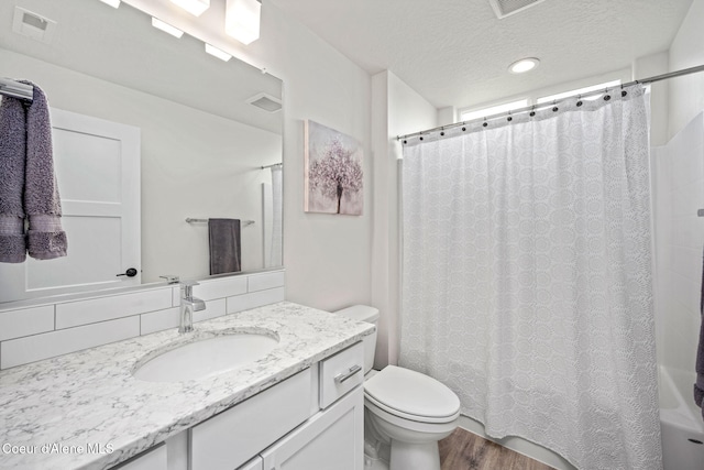 7991 N Girard Cir, Coeur Dalene, ID 83815 - full bathroom featuring vanity, wood finished floors, shower / bathtub combination with curtain, a textured ceiling, and recessed lighting