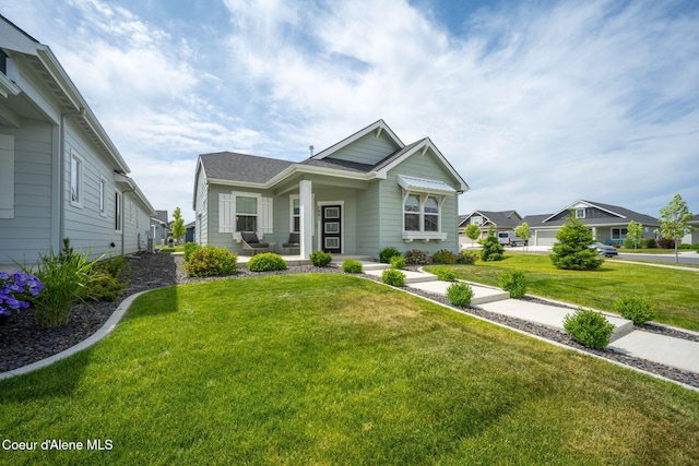 7991 N Girard Cir, Coeur Dalene, ID 83815 - craftsman-style home with a porch, a front lawn, and a shingled roof