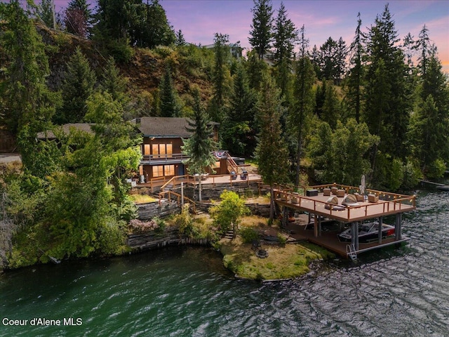 400 S Ohana Beach Dr, Coeur Dalene, ID 83814 - back of property at dusk with a deck with water view and a wooded view