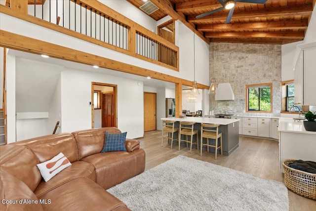 400 S Ohana Beach Dr, Coeur Dalene, ID 83814 - living room featuring ceiling fan, a wooden ceiling with exposed beams, light wood-type flooring, and a high ceiling