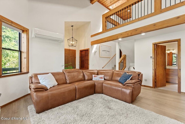 400 S Ohana Beach Dr, Coeur Dalene, ID 83814 - living area featuring a wall mounted air conditioner, high vaulted ceiling, wood finished floors, a chandelier, and stairs
